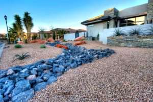 “Applying non-selective herbicide to control weeds in a rock bed near a driveway in St. George, Utah County, Salt Lake County, and Davis County, showing effective weed control in non-grass areas like patios, RV pads, and flower beds.